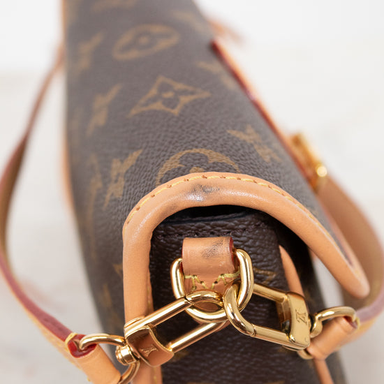 Close-up of a Louis Vuitton handbag with monogram pattern and gold chain detail.