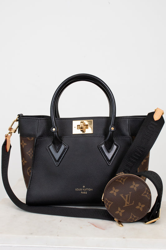 Louis Vuitton handbag with matching round pouch on a light gray background