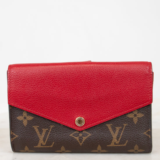 Red wallet with brown monogram pattern on a white background