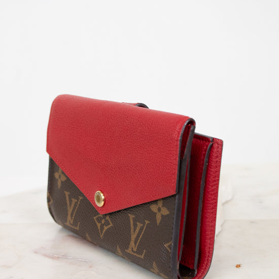 Red and brown wallet with Louis Vuitton monogram pattern on a white background