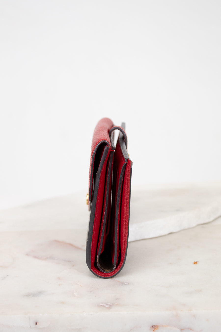 Red side of wallet on a marble surface