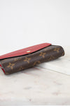 Brown wallet with red interior on a marble surface