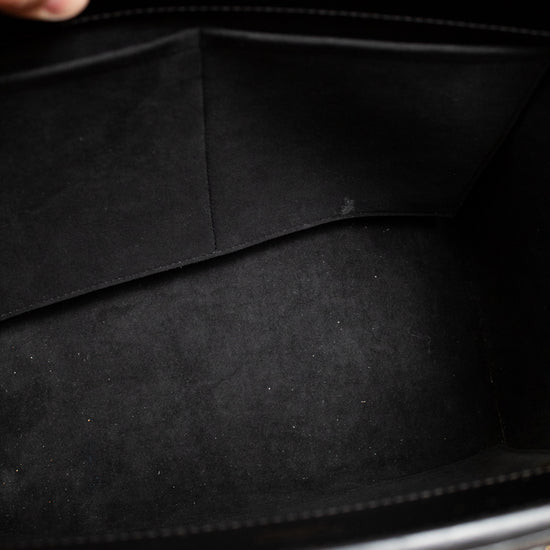 Close-up of a black leather briefcase with a hand holding it open.