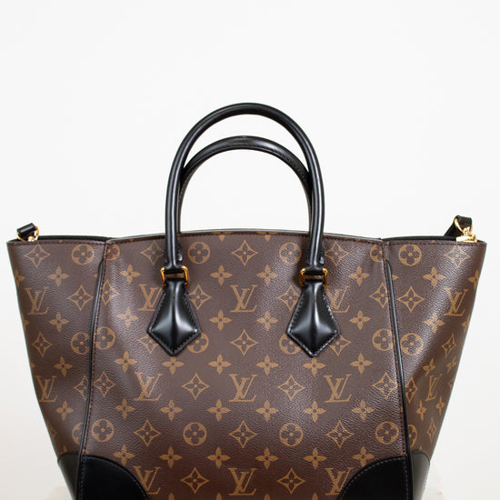 Brown handbag with black handles on a white background