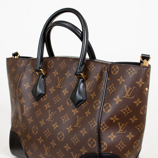 Brown handbag with black handles on a white background