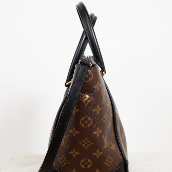 Designer handbag with monogram pattern on a white background