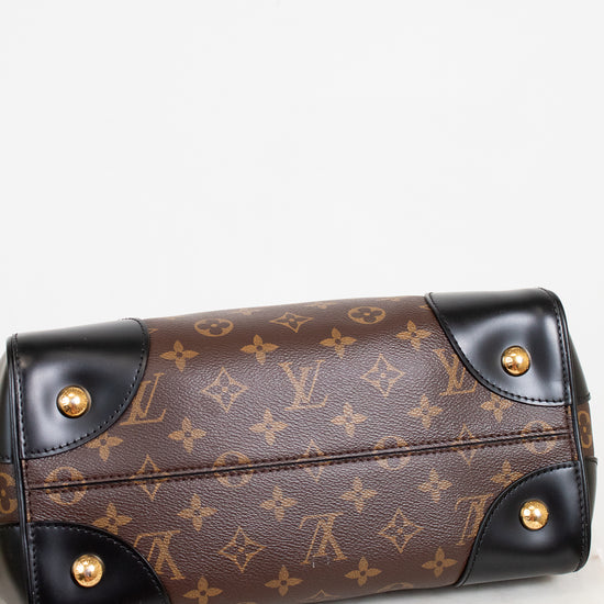 Designer handbag with monogram pattern and gold hardware on a light background