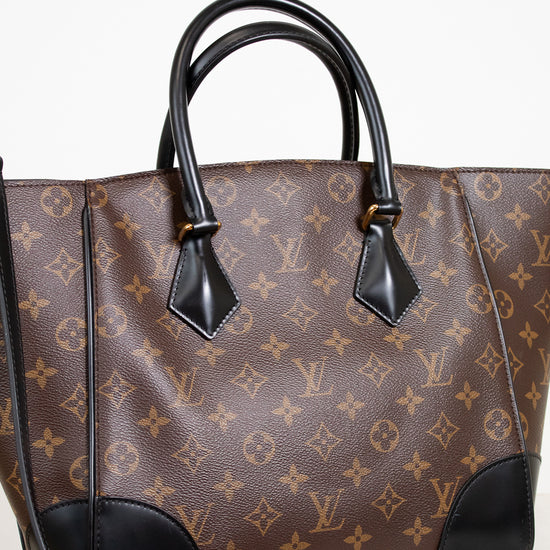 Designer handbag with monogram pattern and black accents on a light background