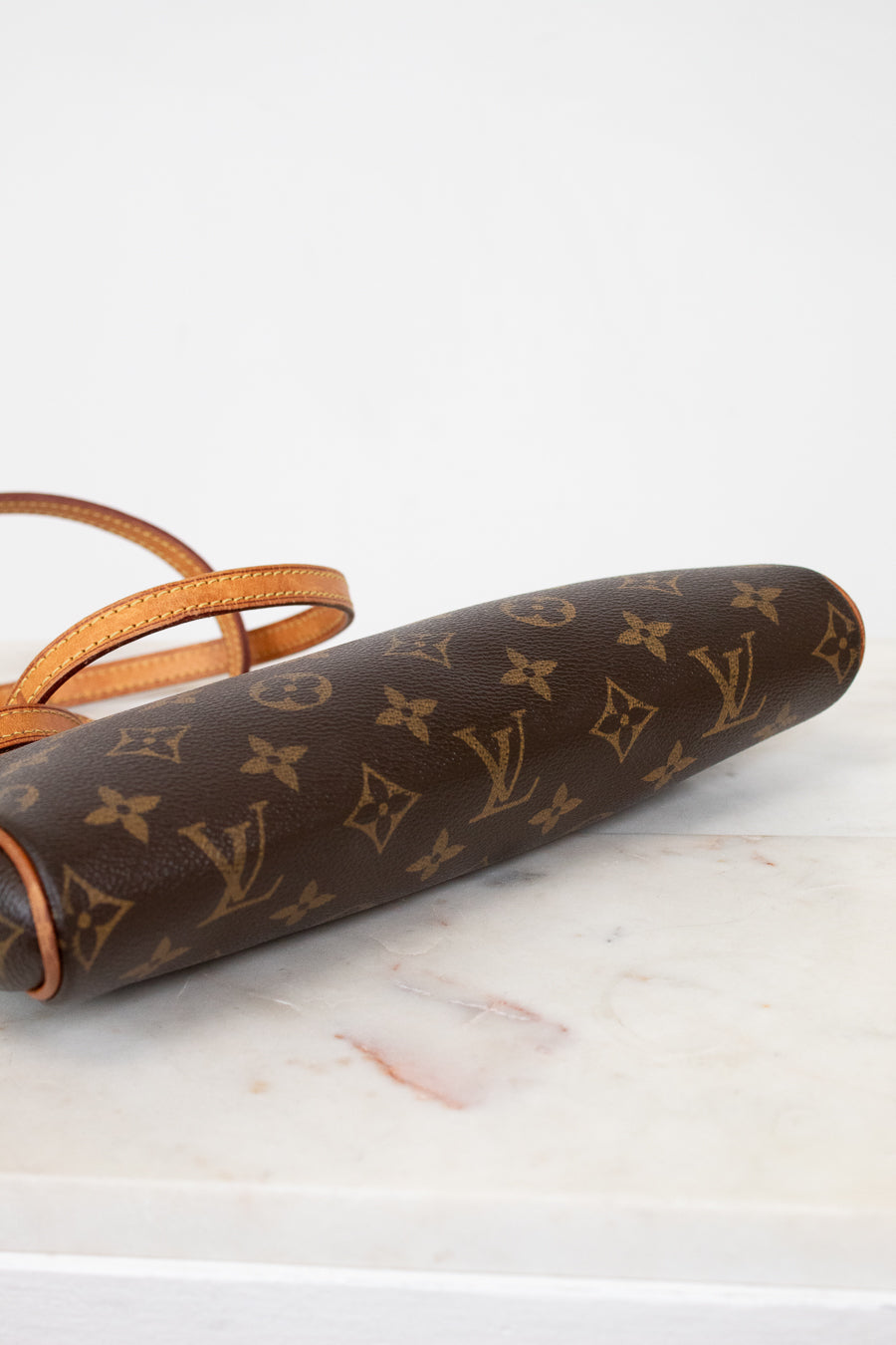 Louis Vuitton monogram clutch on a marble surface