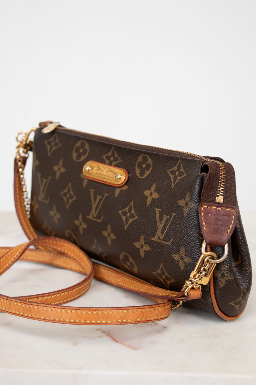 Louis Vuitton monogram handbag with gold hardware on a white background