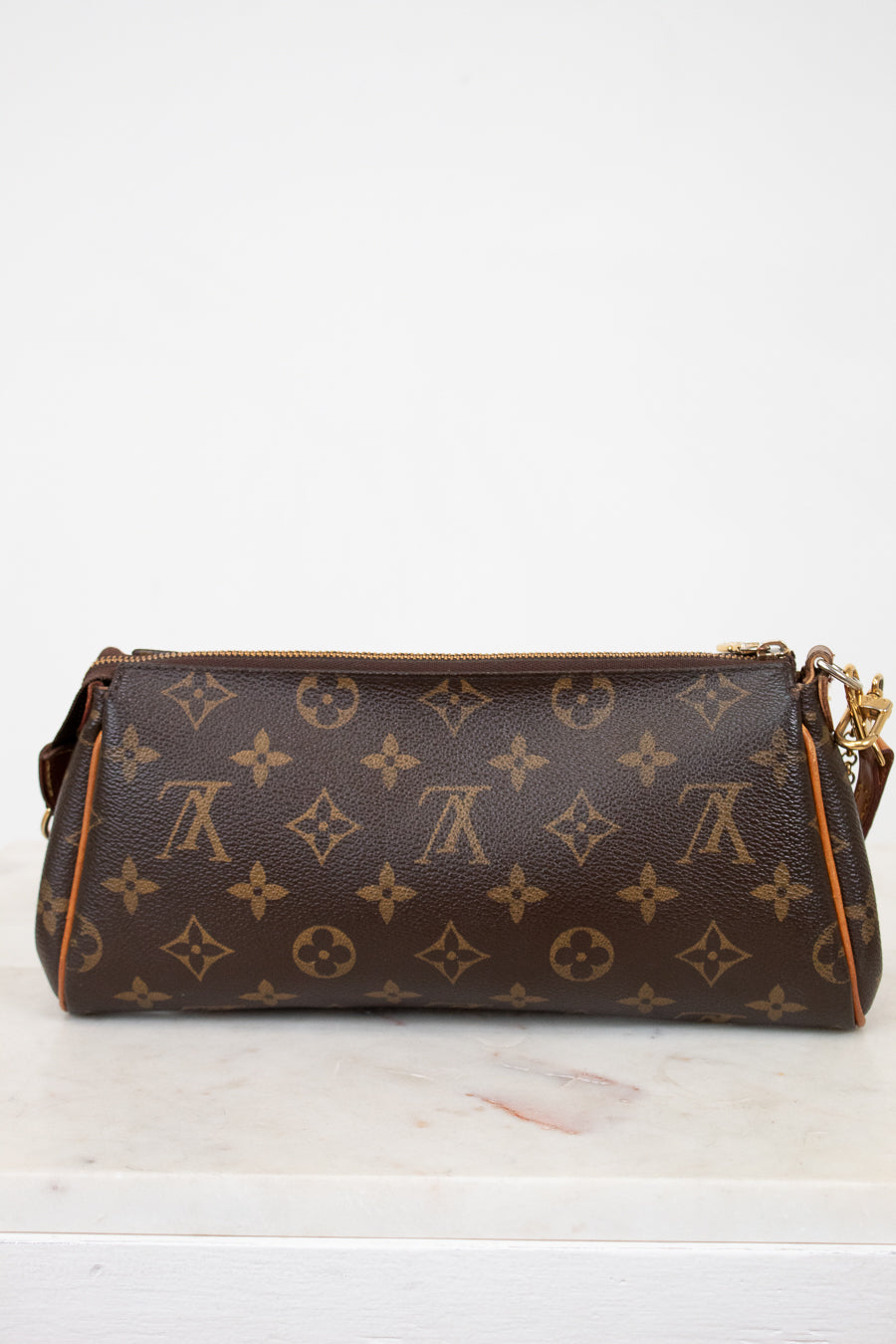 Designer handbag with monogram pattern on a white surface