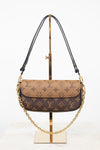 Louis Vuitton monogram shoulder bag in brown and beige coated canvas with gold-tone hardware, displayed on a gold stand against a white background.