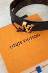 Louis Vuitton belt with gold buckle on an orange Louis Vuitton box