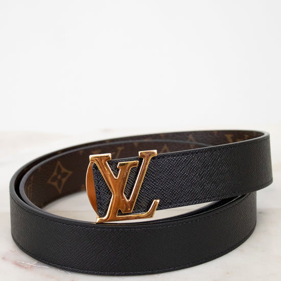 Black belt with gold buckle on a marble surface