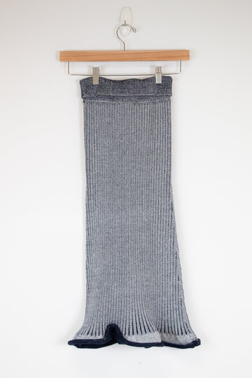 Navy and white ribbed knit skirt hanging on a wooden hanger against a white background