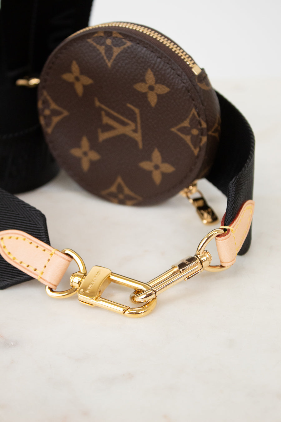 Round monogrammed coin purse with gold clasp on a light background