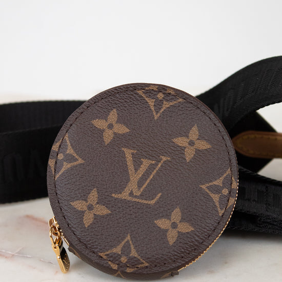 Round brown Louis Vuitton coin purse with monogram pattern on a marble surface.