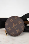 Round brown Louis Vuitton coin purse with monogram pattern on a marble surface.