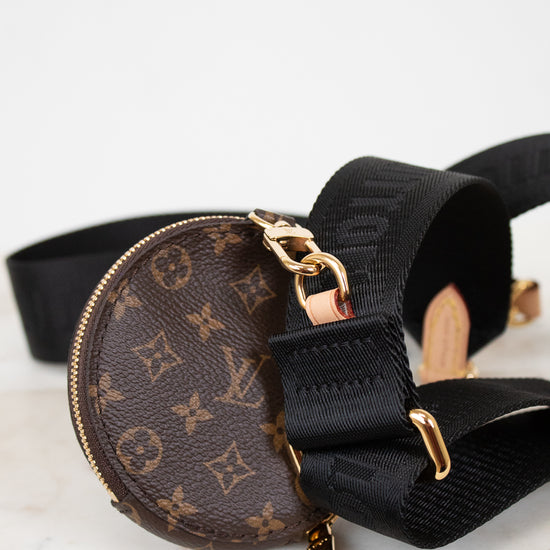 Louis Vuitton monogram bag with black strap on a light background