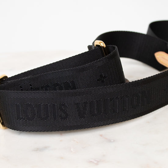 Black Louis Vuitton strap on a marble surface