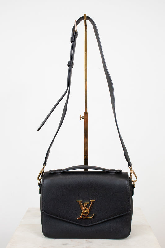 Black handbag with gold accents on a white background