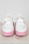 White sneakers with pink soles on a light gray background