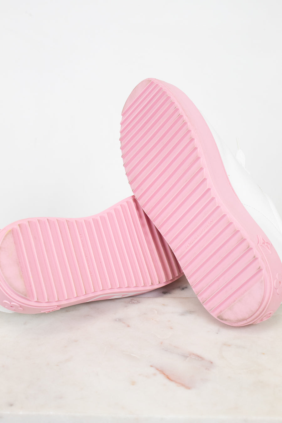 Pink soles of sneakers on a marble surface