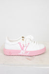 White sneaker with pink sole and logo on a light gray background