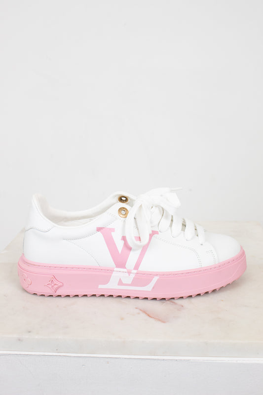 White sneaker with pink sole and logo on a light gray background