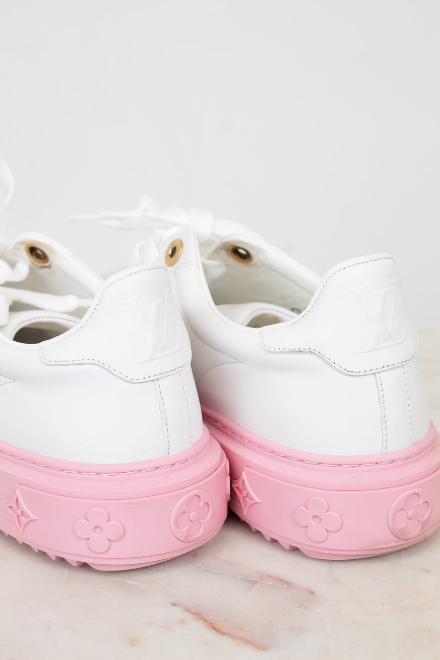White sneakers with pink soles on a light background