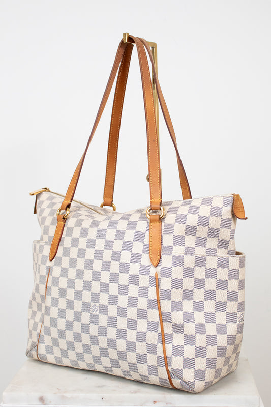 Checkered handbag with brown straps on a white background