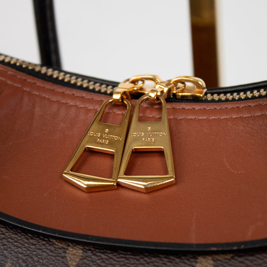 Brown leather handbag with gold hardware on a white background
