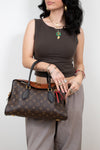 Woman holding a patterned handbag against a plain background