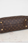 Brown leather handbag with gold studs on a marble surface