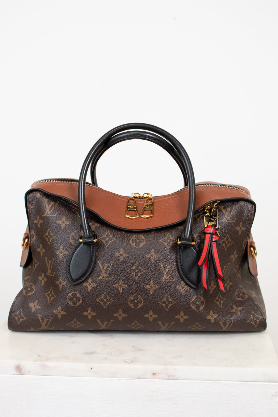 Designer handbag with monogram pattern on a white background