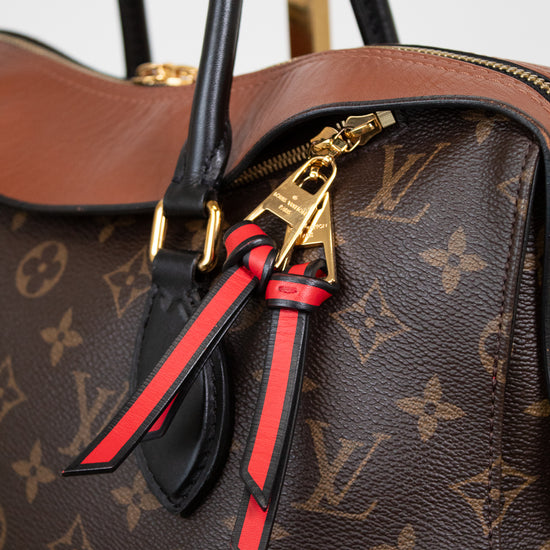 Louis Vuitton monogram handbag with a decorative zippers featuring red and black ribbons.