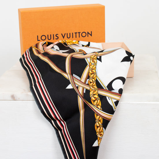 Louis Vuitton scarf with decorative chain print folded with orange box on a white background