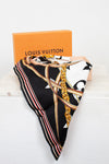 Louis Vuitton scarf with decorative chain print folded with orange box on a white background