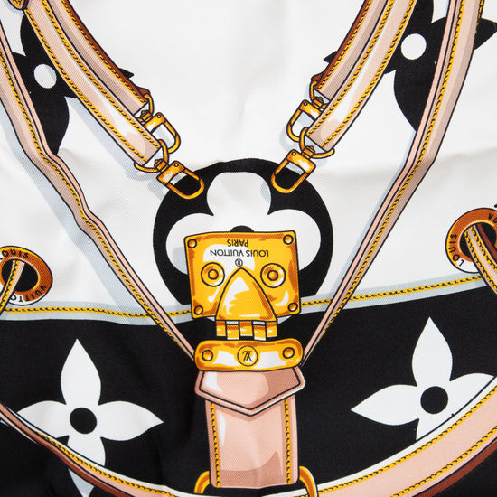 Close up of Louis Vuitton scarf showing detail print that looks like purse straps and purse hardware closure