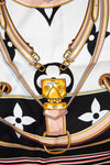 Close up of Louis Vuitton scarf showing detail print that looks like purse straps and purse hardware closure