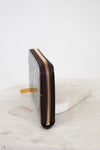 Maroon wallet with gold zipper on a marble surface