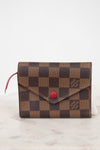 Designer wallet with checkered pattern and red accent on a white background