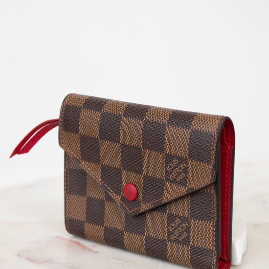 Louis Vuitton wallet with checkered pattern on a white surface