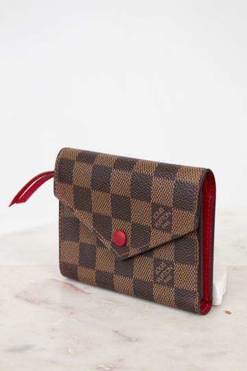 Louis Vuitton wallet with checkered pattern on a white surface