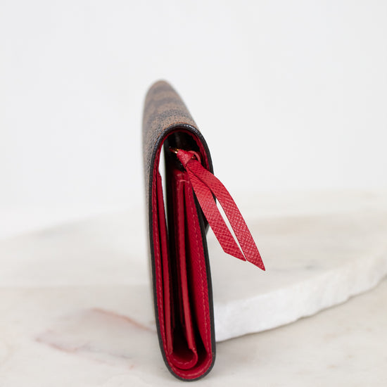 Red side profile of wallet with a red interior on a white marble surface