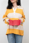 Person wearing a yellow and beige striped shirt holding an open red wallet against a white background