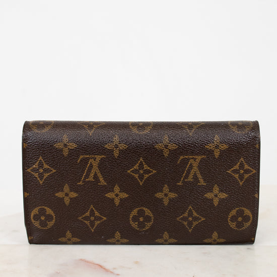 Louis Vuitton wallet with monogram pattern on a marble surface