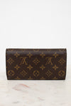 Louis Vuitton wallet with monogram pattern on a marble surface