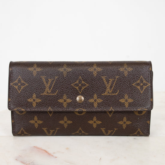 Louis Vuitton wallet with monogram pattern on a marble surface