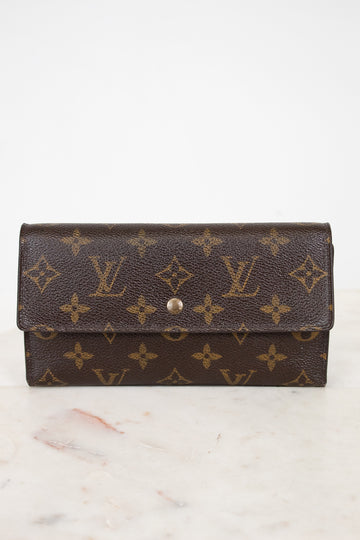Louis Vuitton wallet with monogram pattern on a marble surface
